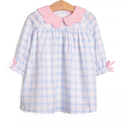  This dress features a blue and pink plaid fabric, a pink scalloped collar, and pink sleeve ties. 
