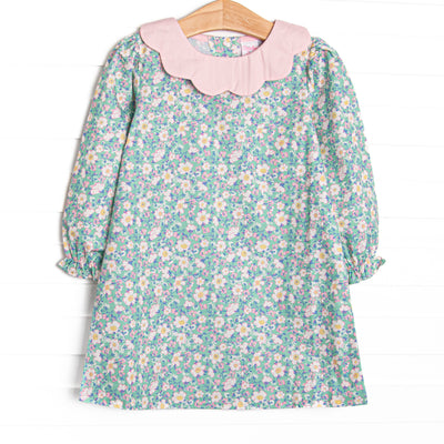  This dress features a green floral print, a pink petal collar, and button closure on the back. 