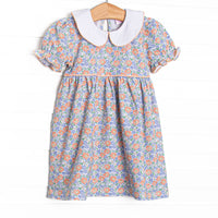This dress features a blue floral print, puff sleeves, and a peter pan collar.