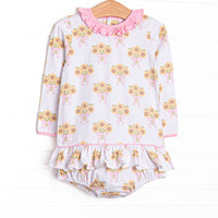This skirted bubble features a sunflower print, a pink ruffle neck, and long sleeves.