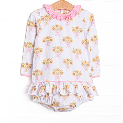 This skirted bubble features a sunflower print, a pink ruffle neck, and long sleeves.