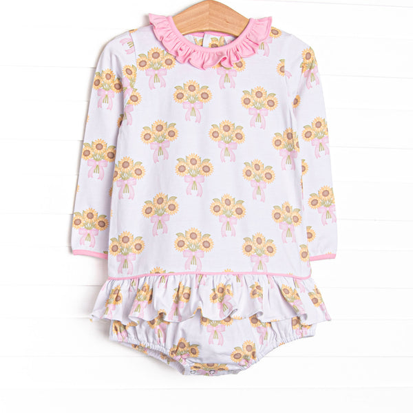 This skirted bubble features a sunflower print, a pink ruffle neck, and long sleeves.