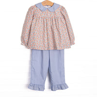 This set features a floral print, a blue scalloped collar, and long sleeves. Coordinating blue ruffle pants to match.