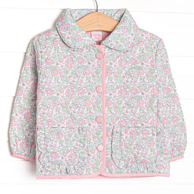  This coat features a green floral quilted material, a peter pan collar, and pink buttons. 