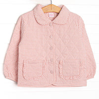 This coat features a pink gingham quilted material, a peter pan collar, and pink buttons