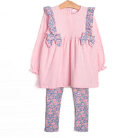 This set features a pink top with purple floral ruffles and side ties. Coordinating purple floral leggings to match.