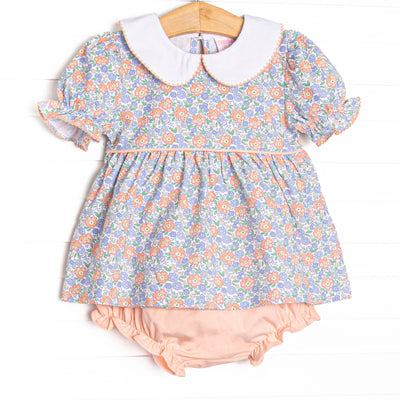 This set features a blue floral print, puff sleeves, and a peter pan collar. coordinating peach pink diaper cover to match.