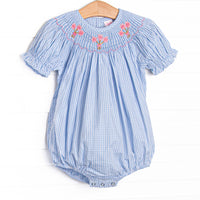 This bubble features blue gingham fabric, floral smocking, and short puff sleeves.