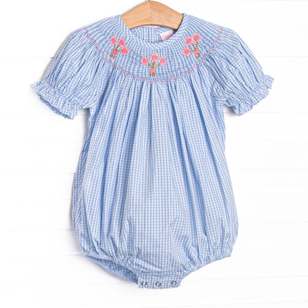 This bubble features blue gingham fabric, floral smocking, and short puff sleeves.