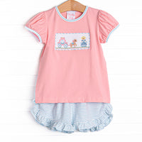 This set features puff sleeves, a carriage smocking, and aqua striped ruffle shorts.
