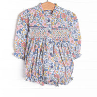 This bubble features a navy floral fabric, dainty smocking, and front buttons.