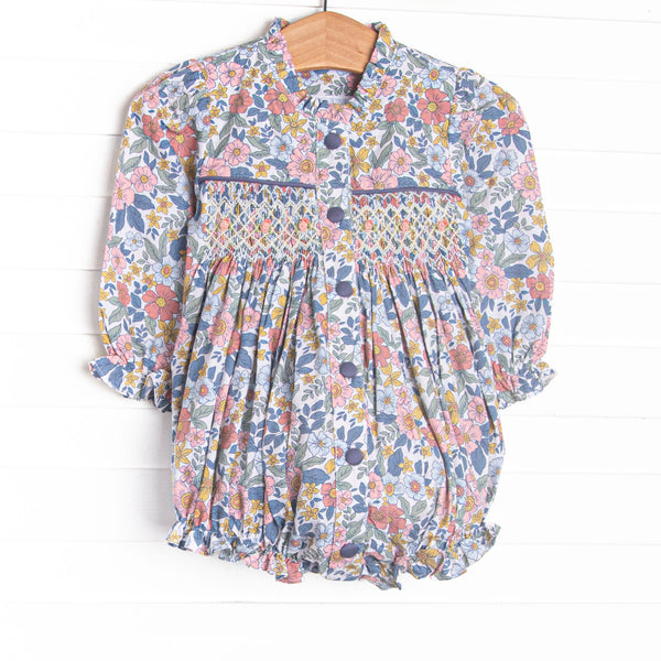 This bubble features a navy floral fabric, dainty smocking, and front buttons.