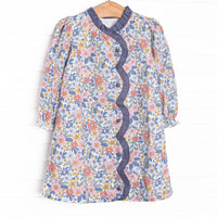 This dress features a navy floral fabric, ruffle trim , and front buttons.