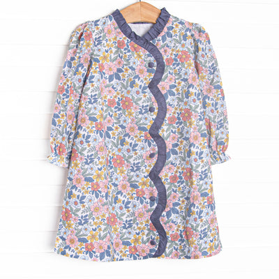 This dress features a navy floral fabric, ruffle trim , and front buttons.