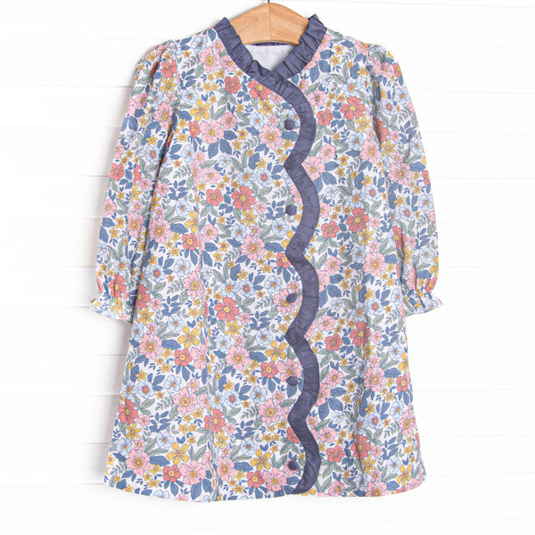 This dress features a navy floral fabric, ruffle trim , and front buttons.