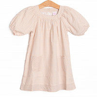  This dress features tan gingham fabric, puff sleeves, and front pockets. 