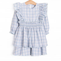 This dress features a blue and tan plaid fabric, waist smocking, and flutter sleeves.