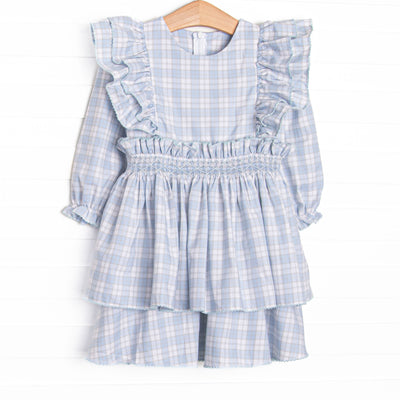 This dress features a blue and tan plaid fabric, waist smocking, and flutter sleeves.