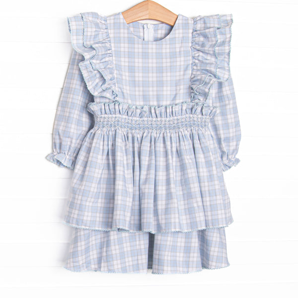 This dress features a blue and tan plaid fabric, waist smocking, and flutter sleeves.