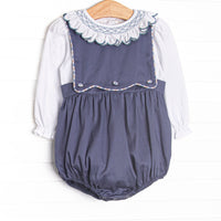 This bubble features a navy corduroy fabric, a button on bib, and white long sleeve top with a smocked scallop collar.