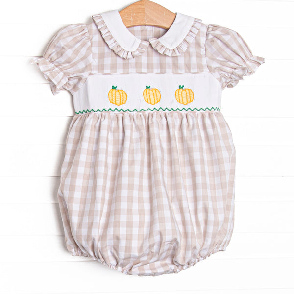 This bubble features a tan check print, a trio of pumpkin smockings, and puff sleeves.