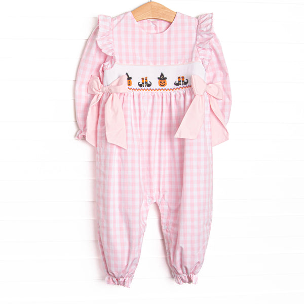  This romper features pink gingham fabric, Halloween smocking, and pink side ties. 