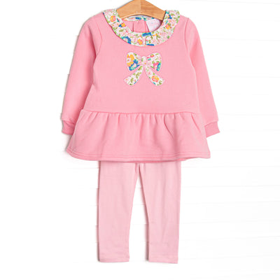 This sweatshirt set features pink knit fabric, floral ruffle trim, and a floral bow applique. Coordinating pink leggings to match.