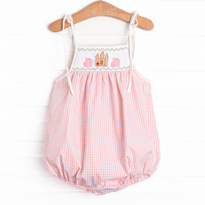  This bubble features a pink gingham print, shoulder ties, and castle smockings. 
