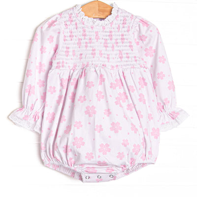  This bubble features pink floral print, chest smocking, and eyelet lace trim. 