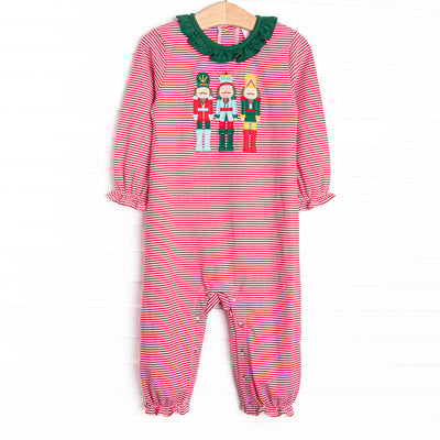 This romper features a red striped print, green ruffle collar, and a trio of toy soldiers applique.