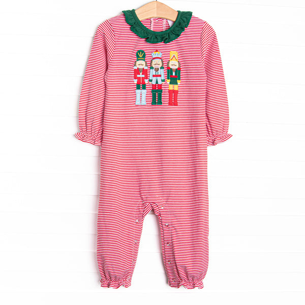 This romper features a red striped print, green ruffle collar, and a trio of toy soldiers applique.