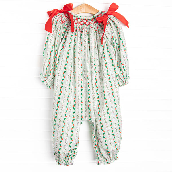  This romper features a holly print, red bows, and a dainty smocking. 