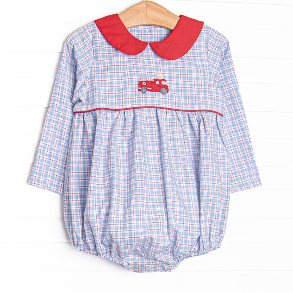 This bubble features blue and red plaid fabric, firetruck embroidery, and a red Peter Pan collar.