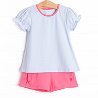 The set features a blue stripe top, pink trim, and pink ruffle shorts to match.