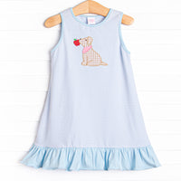  This dress features a blue striped print, blue ruffles, and a puppy applique. 