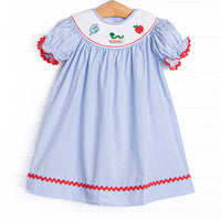This dress features a blue striped print, red ric rac trim, and a school smocking.