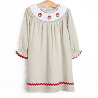 This dress features a sage green gingham print, red ric rac trim, and a trio of wreath smockings