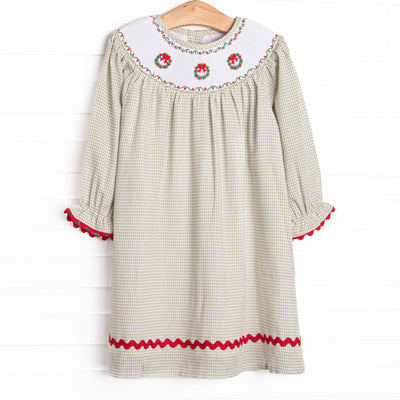 This dress features a sage green gingham print, red ric rac trim, and a trio of wreath smockings