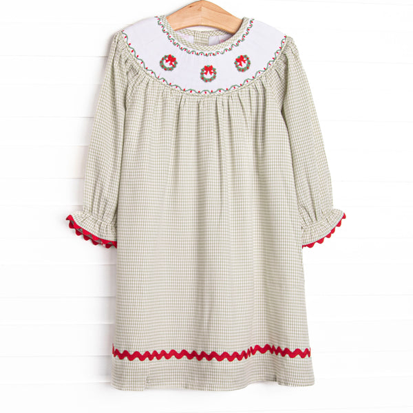 This dress features a sage green gingham print, red ric rac trim, and a trio of wreath smockings