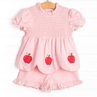  This set features a pink gingham print, puff sleeves, and apple trio applique. Coordinating ruffle shorts to match.
