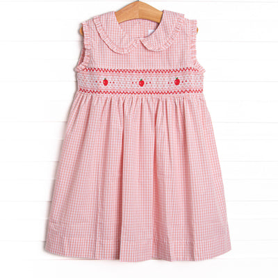  This dress features a pink gingham print, a peter pan collar, and an apple smocking. 