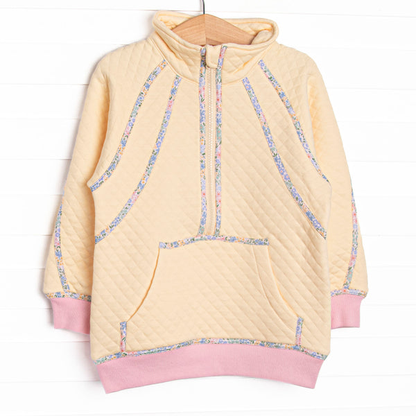  This pullover features yellow fleece fabric, floral trim, and a half zip. 