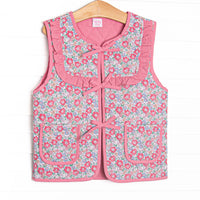  This reversable vest features pink fabric on one side, pink floral fabric on the other, a tie front, and front pockets. 