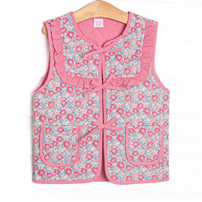 This reversable vest features pink fabric on one side, pink floral fabric on the other, a tie front, and front pockets. 