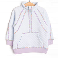 This pullover features blue fleece fabric, floral trim, and a half zip