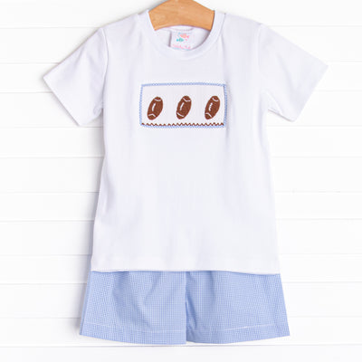 This set features short sleeve top with a trio of football smocking and blue mini gingham shorts to match.