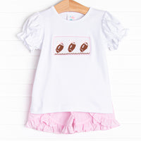  This set features short puff sleeve top with a trio of football smocking and pink mini gingham ruffle shorts to match. 