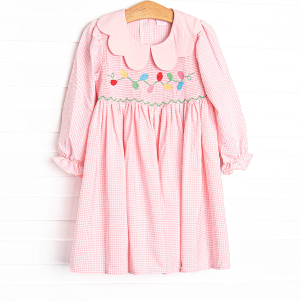  This dress features a pink gingham print, a scalloped collar, and a smocking of Christmas lights. 