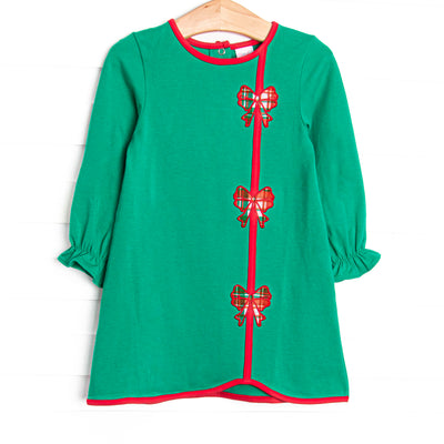  This dress features a green material, red trim, and bow appliques. 
