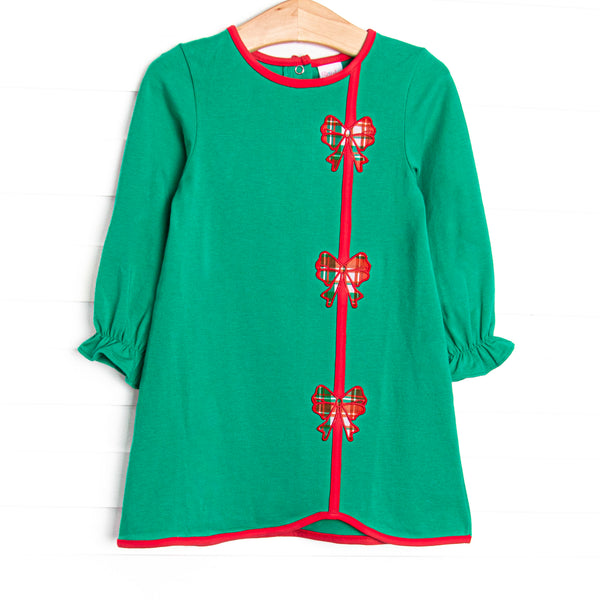  This dress features a green material, red trim, and bow appliques. 